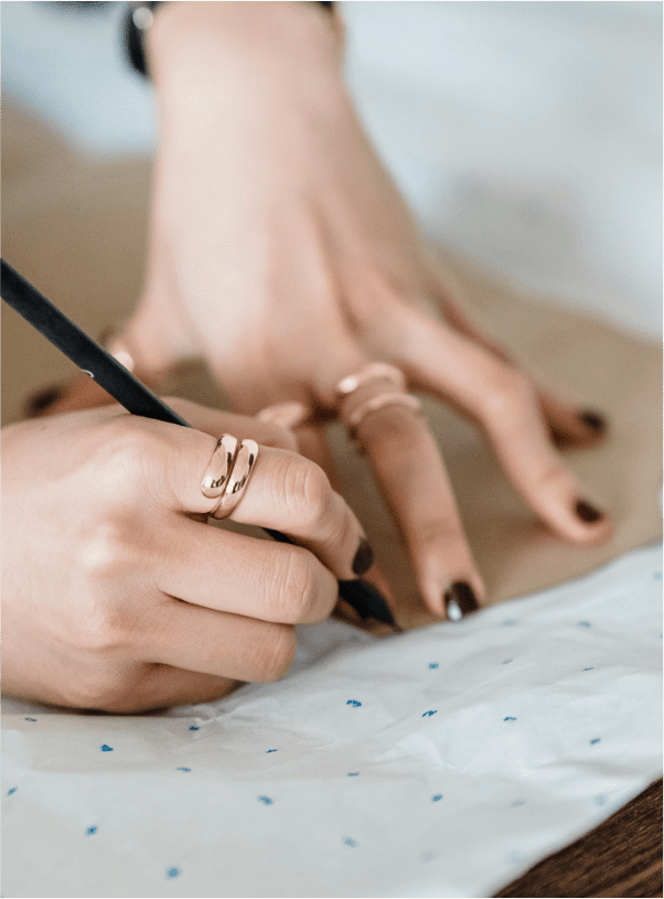 image of woman’s hands as she drafting a pattern