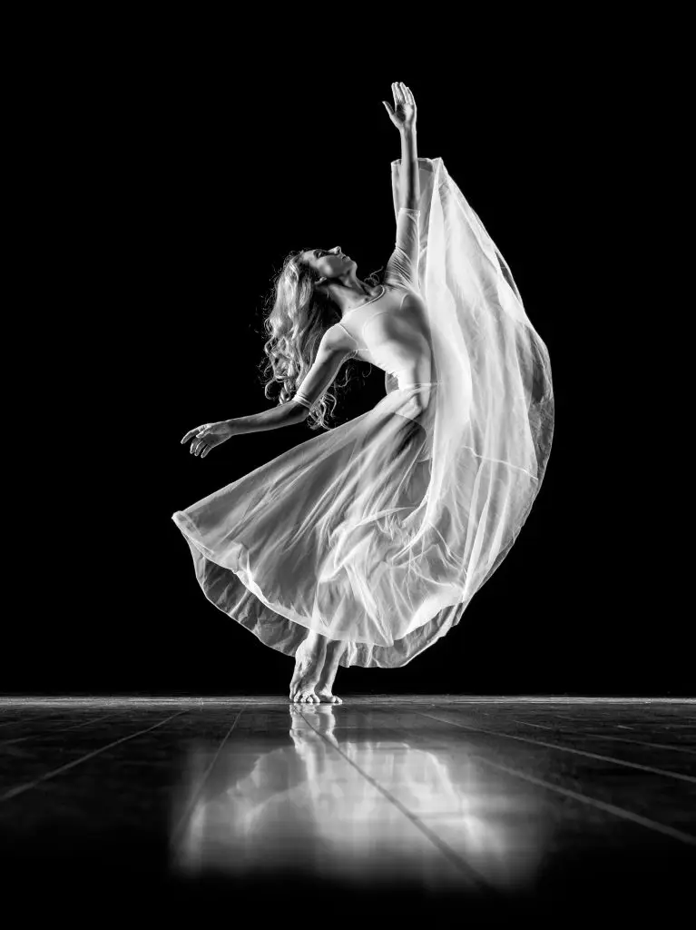 Picture, black, and white of a dancer on a stage in a flow lyrical costume