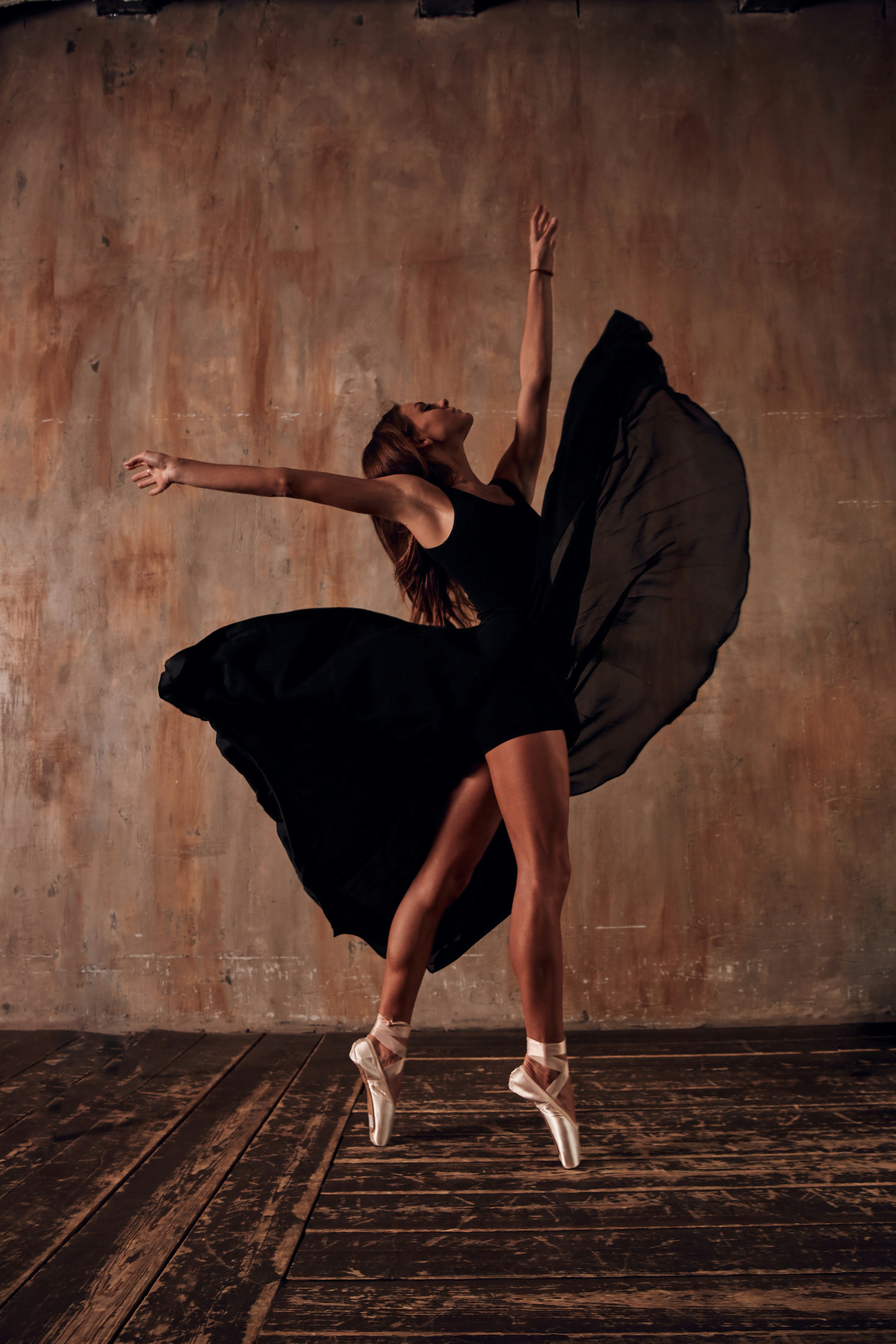 Dancer in black costume and long flowing skirt dancing on pointe … demonstrating garment care for longevity of your Dancewear importance