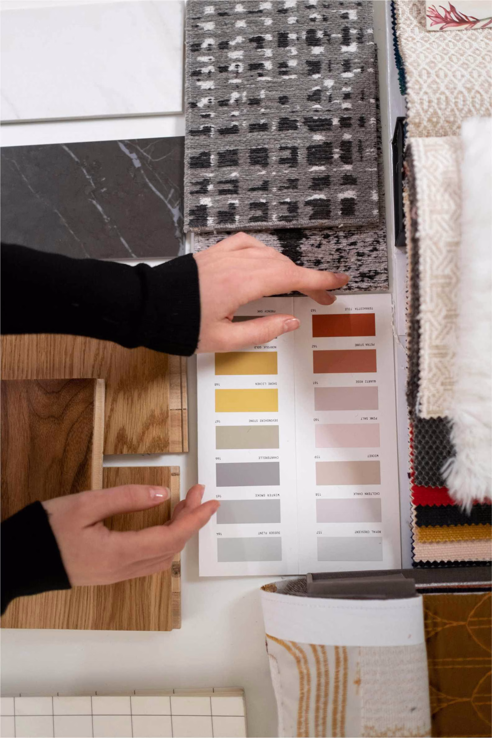 hands of a designer feeling and looking at samples of colors, textures and materials for a collaboration in designing
